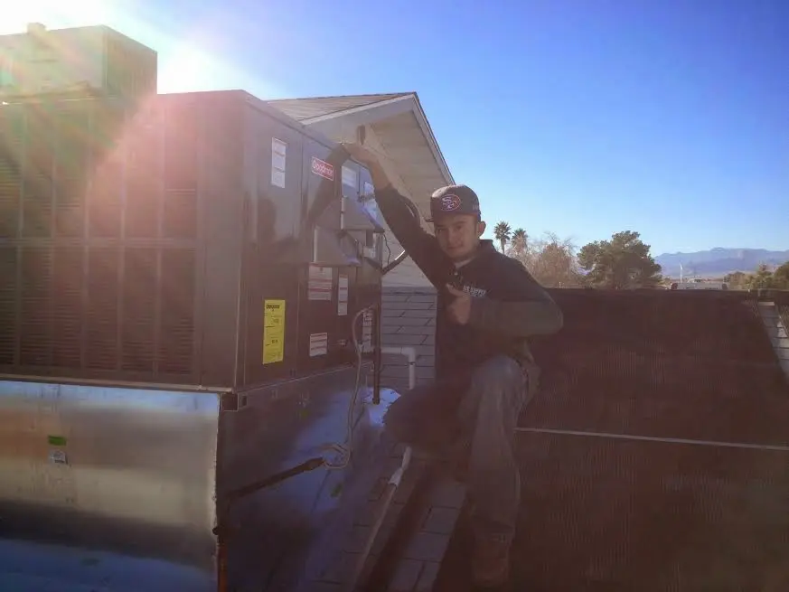 HVAC technician performing Air Duct Cleaning on a rooftop unit in Pike Creek